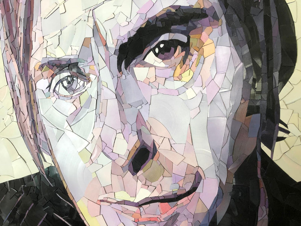 Ed Chapman mosaic portrait of Paul Weller created from broken vinyl records, with layered fragments in pale lilac, cream, and soft pink tones forming a striking likeness of the British music icon.
