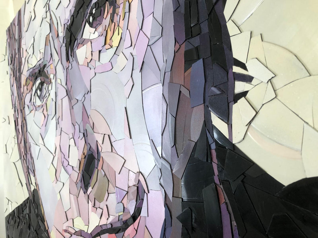 Ed Chapman mosaic portrait of Paul Weller created from broken vinyl records, with layered fragments in pale lilac, cream, and soft pink tones forming a striking likeness of the British music icon.