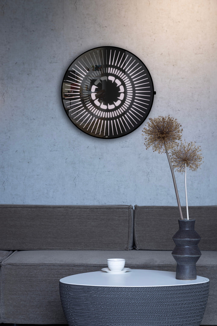 “Tempus Obsidian” by Ben Rousseau – a limited-edition illuminated wall timepiece crafted from grey mirrored glass and brass-tinted aluminium with LEDs. Inspired by obsidian, it radiates calm through subtle light and refined design.

