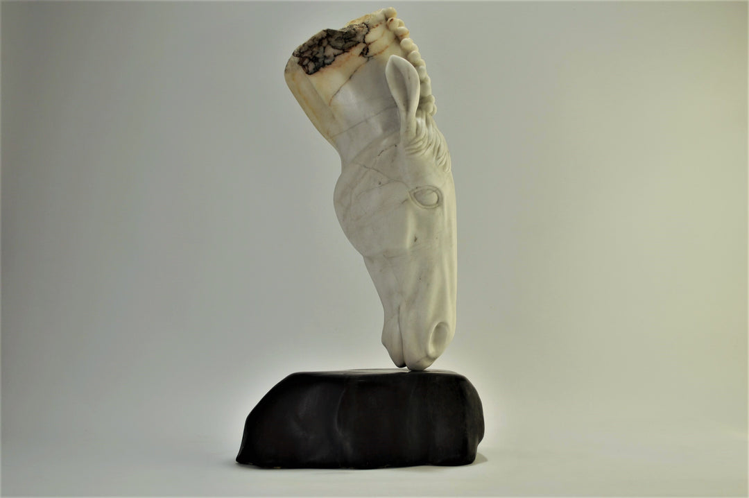 Deborah Harrison sculpture Palomo, a one-off hand-carved horse head in rainbow alabaster with intricate mane detail and a natural crown of rounded alabaster spheres, mounted on a dark soapstone base. The alabaster reveals soft white, ivory, cream and golden brown tones with darker natural veining, blending realism with symbolic form.