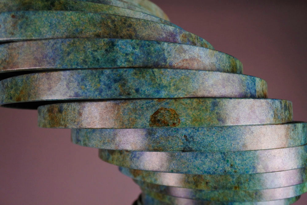 Vortex II by Thomas Joynes – a limited edition bronze sculpture with artisan patina, exploring Fibonacci-based forms through stacked, spiralling discs. The rich verdigris patina in green-blue and rust tones highlights the rhythmic, wave-like movement of the bronze layers. Mounted on a smooth Carrara marble base, the piece brings a sense of elegance and kinetic energy to any contemporary interior.