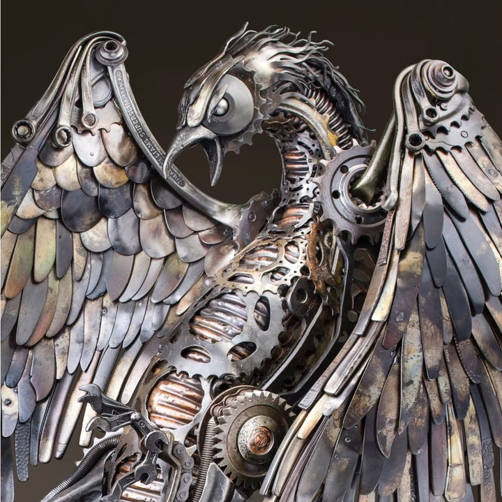 Winged steampunk Phoenix sculpture crafted from reclaimed metal with mechanical detailing and flowing tentacle-like elements.