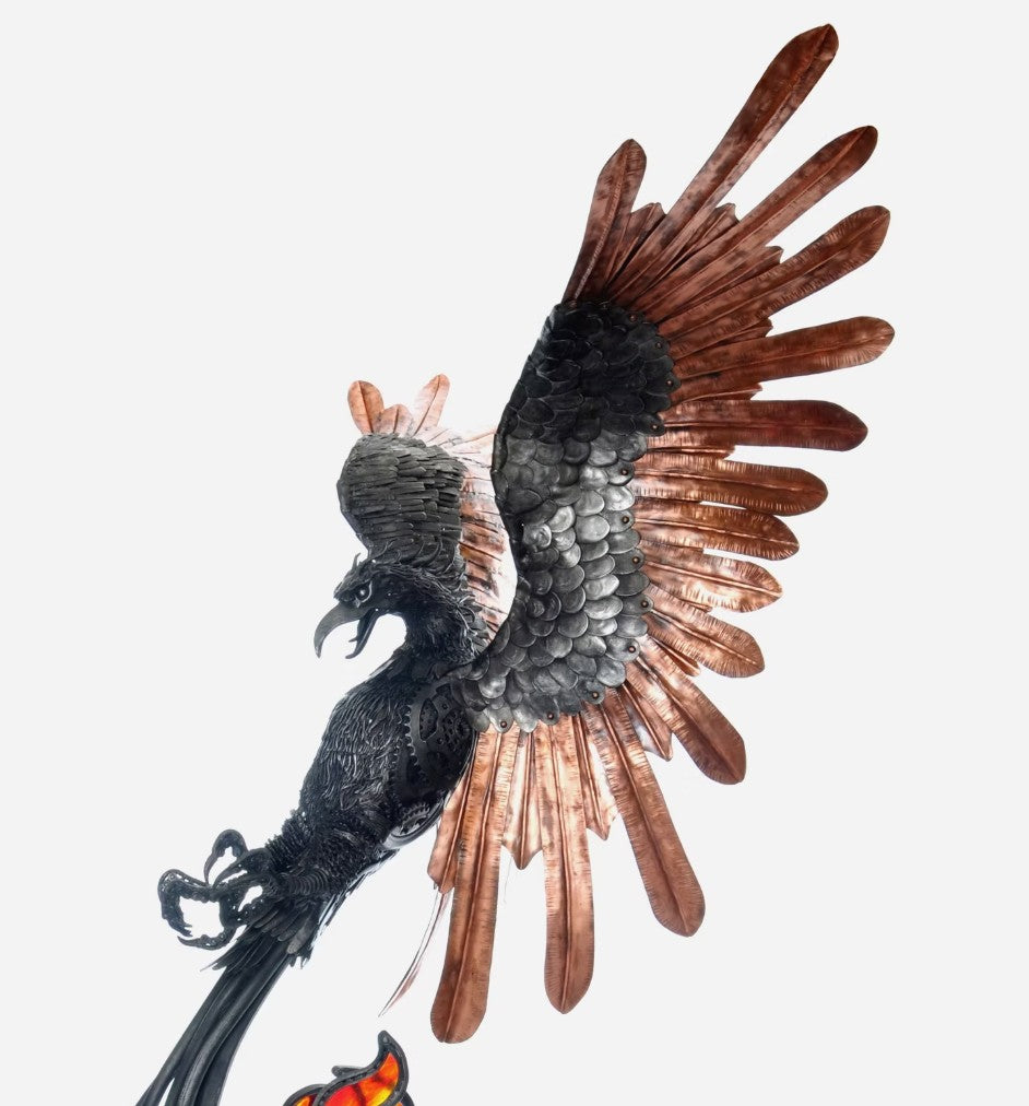 Winged steampunk Phoenix sculpture crafted from reclaimed metal with mechanical detailing and flowing tentacle-like elements.