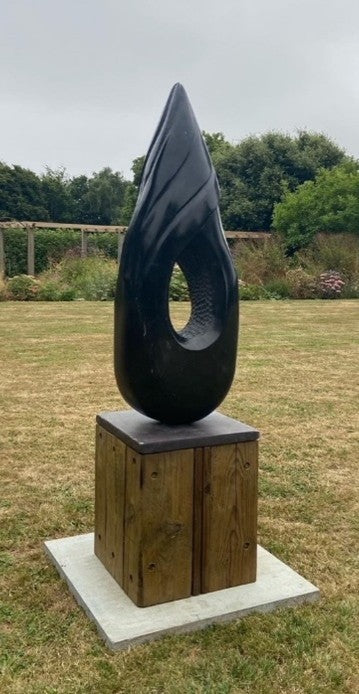 Black Swirl by Brendan Cullen, hand-carved from Nero Marquina and Spanish marble, a tall polished black sculpture with fluid swirling curves and an open centre revealing textured detailing.