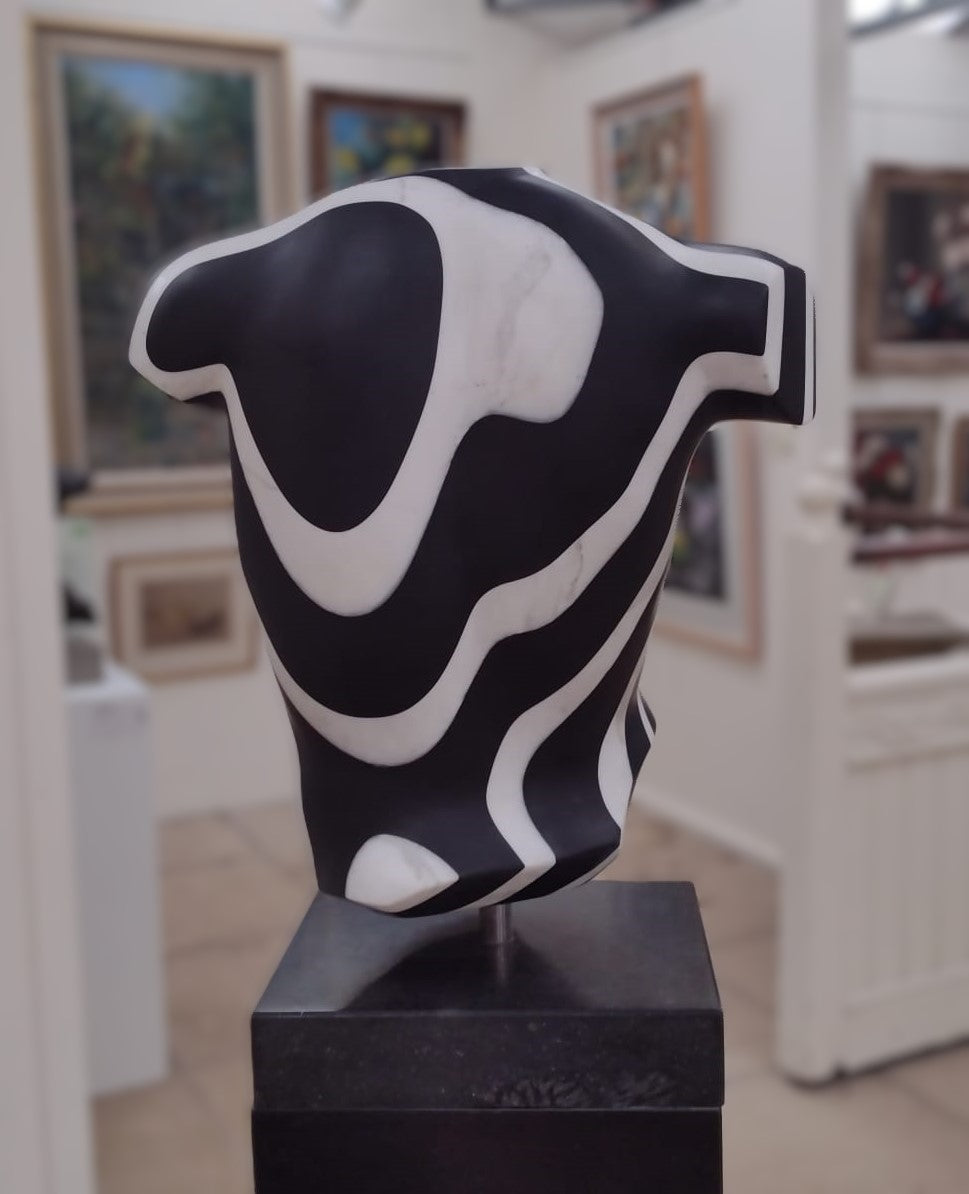 Striking male torso sculpture crafted from Italian white marble and slate, featuring bold organic contour lines in high-contrast black and white, displayed on a dedicated base for interior presentation.
