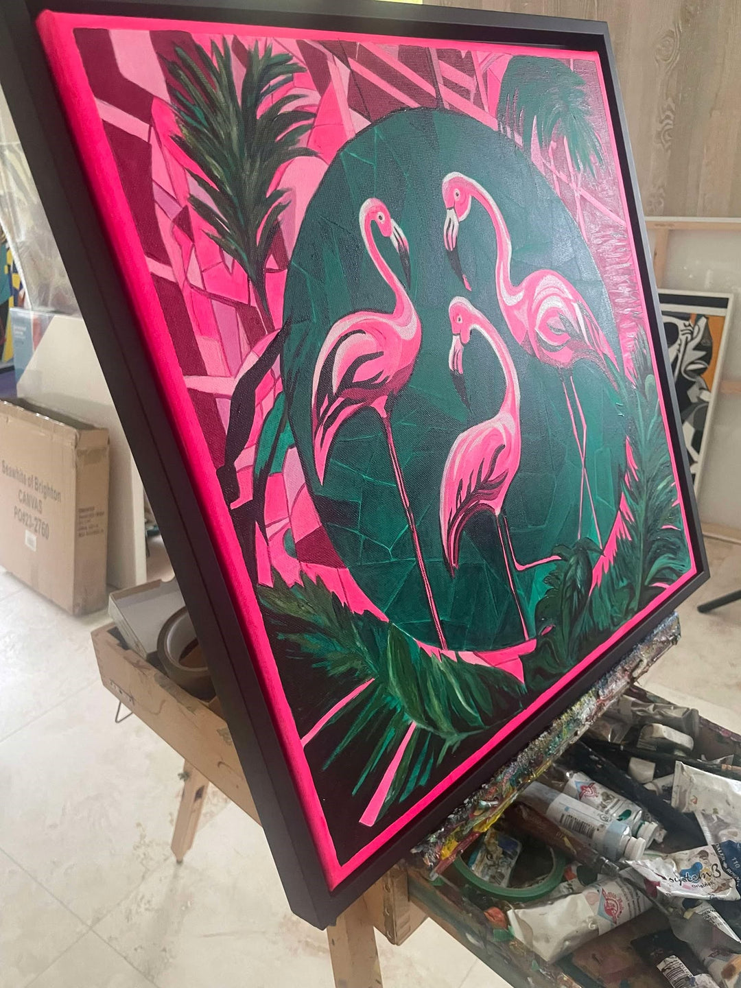 Bold contemporary painting of three pink flamingos set against a geometric green and magenta jungle backdrop.

