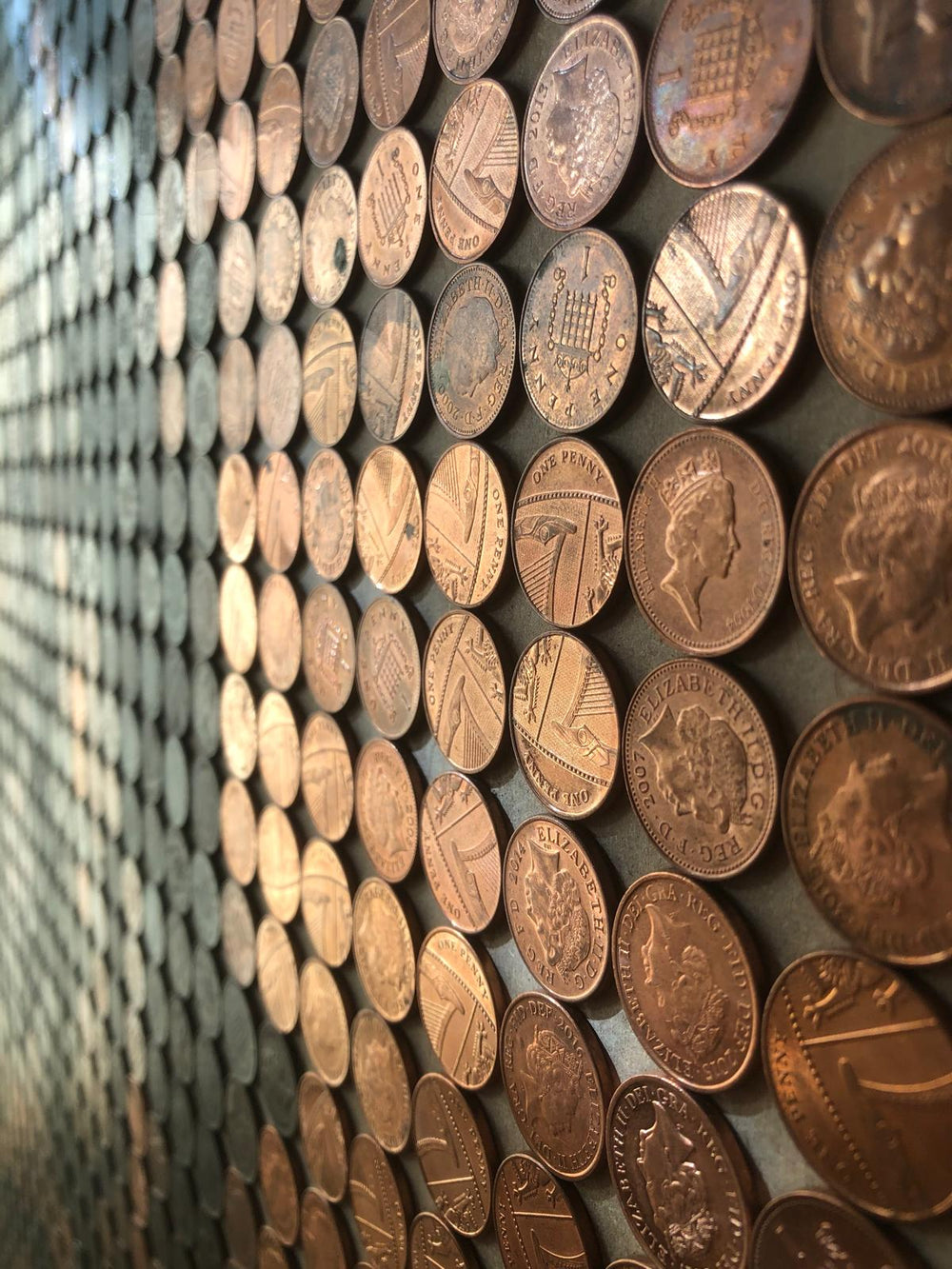 Ed Chapman mosaic portrait of Queen Elizabeth II crafted from over 2,300 British one penny coins, forming a shimmering copper-toned tribute to the late monarch.