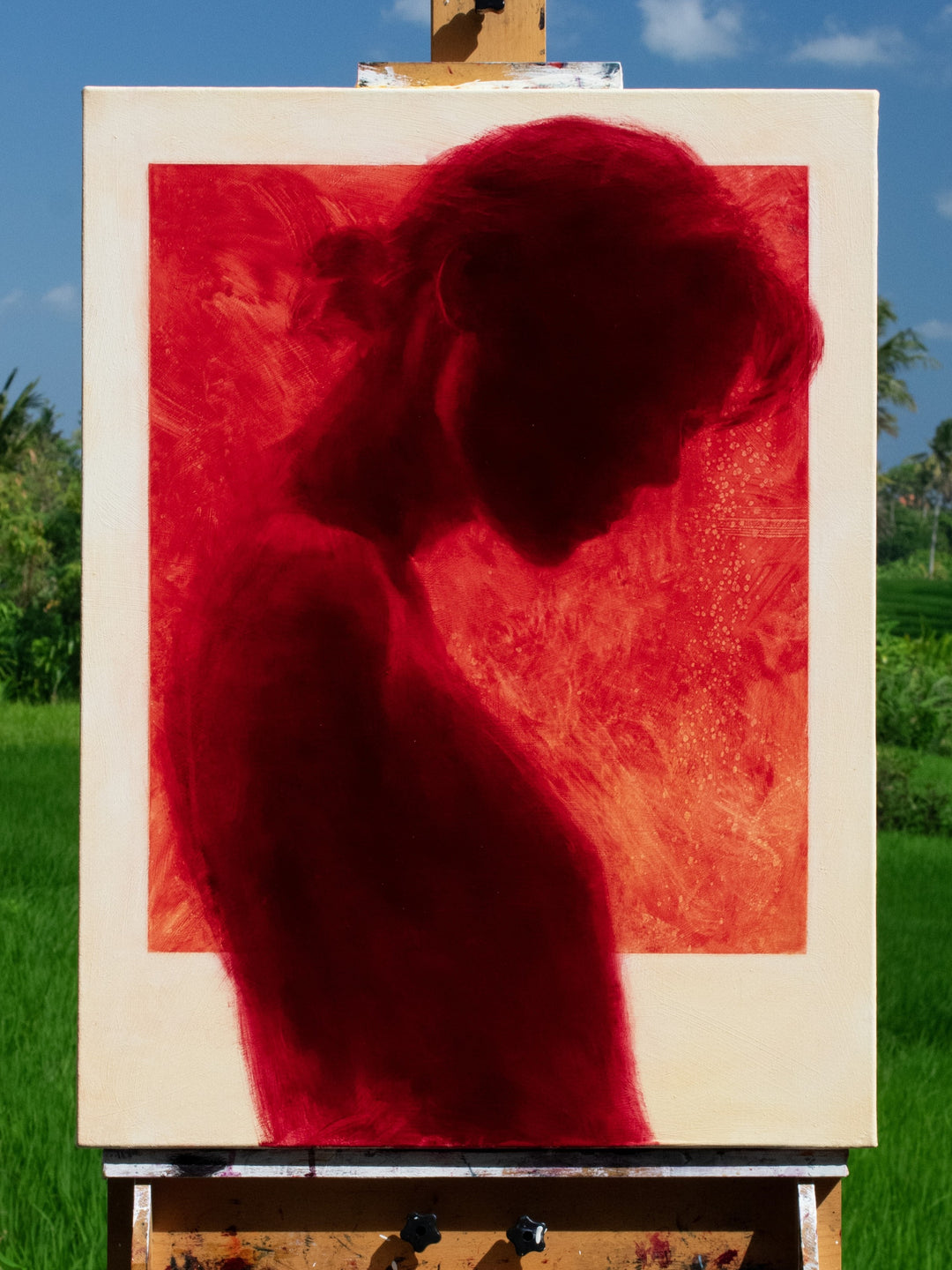 Oil on canvas painting by Dan Bullock, titled Radiance. A striking silhouette portrait of a woman in profile, painted entirely in deep crimson red within a bold rectangular frame, set against a neutral canvas ground. The figure’s bowed head and soft edges evoke intimacy and contemplation, with rich tonal depth and glowing intensity.