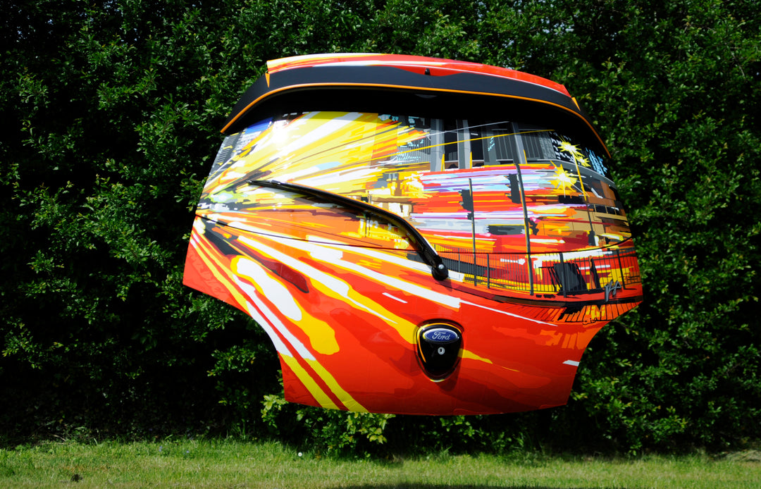 Vibrant custom-painted Ford car boot with dynamic cityscape and motion blur effects in red, yellow, and orange tones.
