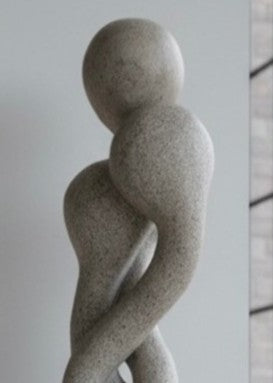Carved abstract figurative sculpture formed from a single block of Blue and Buff Ancaster Weatherbed stone, with intertwined vertical forms rising from an Ancaster stone plinth, featuring smooth flowing contours, subtle surface texture and balanced proportions designed for indoor display.