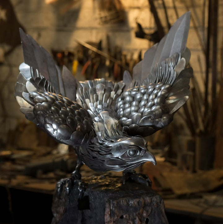 Close-up of a handcrafted metal hawk sculpture with outstretched wings, captured with sparks in the background.