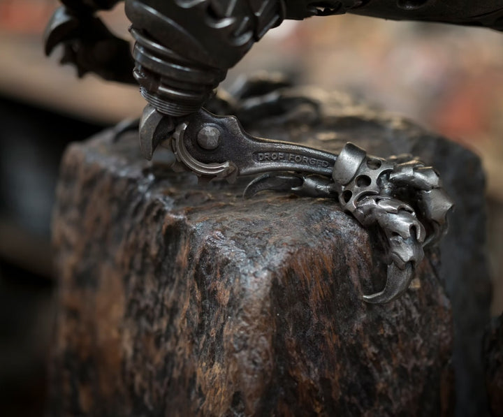 Close-up of a handcrafted metal hawk sculpture with outstretched wings, captured with sparks in the background.