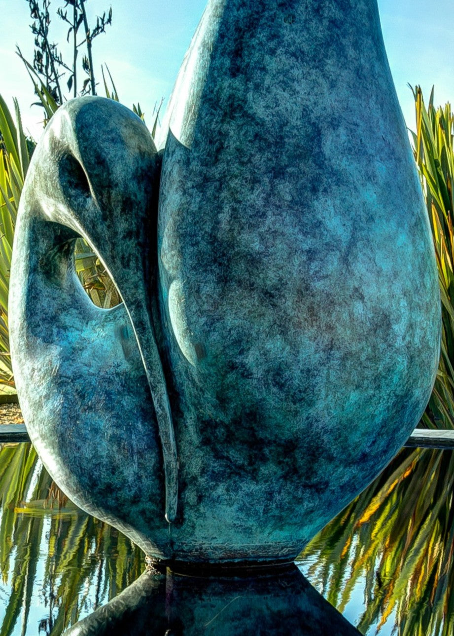 Simon Gudgeon bronze sculpture Reflection featuring an elegant abstract organic form with sweeping curved bronze surfaces displayed within a landscaped outdoor setting.