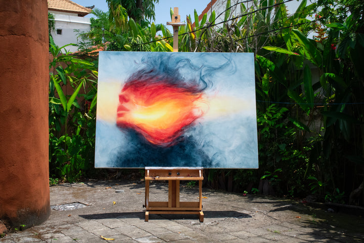 Large oil on canvas painting by Dan Bullock, titled Reverie. A dreamlike portrait of a female face in profile, dissolving into swirling colours of fiery red, orange, and golden yellow, contrasted with cool blue and smoky black tones. The composition radiates energy and motion, blending realism with abstraction.
