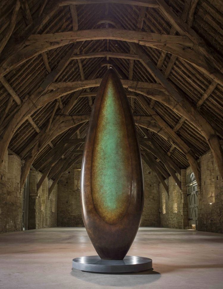 Monumental bronze sculpture by Dominic Welch, Rising Form VI, standing over 2.5 metres tall. The elongated leaf-like form features a smooth, tapering silhouette with a central turquoise-green patinated core against rich bronze tones. A powerful outdoor or architectural piece, it radiates elegance, presence, and organic energy.