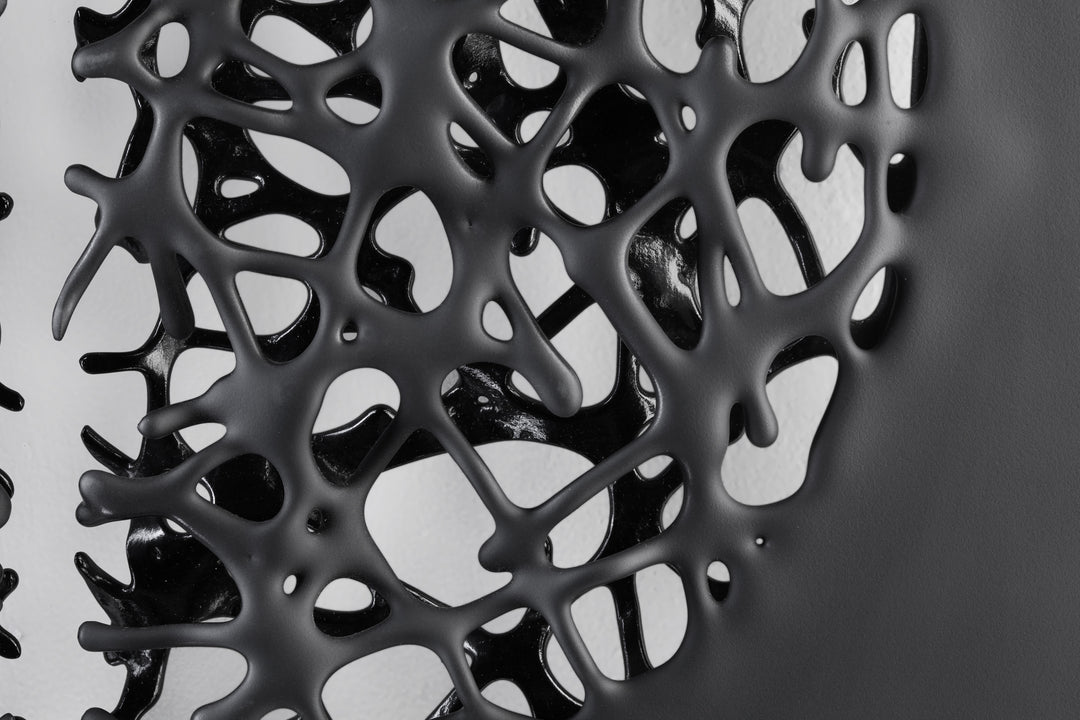 Tracy Nicholls glass wall sculpture Riven — a one-off artwork of two black glass panels forming an orb when placed side by side. The intricate webbed structure undulates with organic movement, featuring a satin-smooth exterior contrasting with a glossy black inner surface that glimmers through the open lace-like forms.