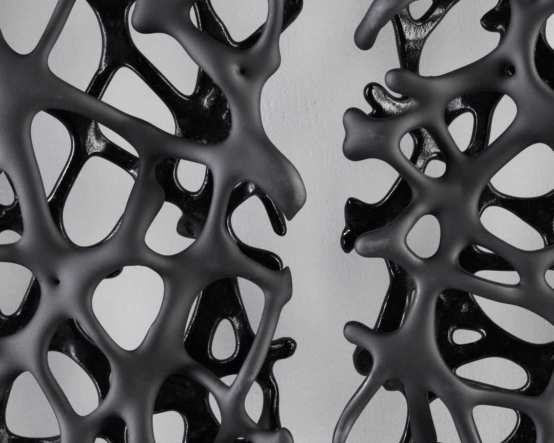 Tracy Nicholls glass wall sculpture Riven — a one-off artwork of two black glass panels forming an orb when placed side by side. The intricate webbed structure undulates with organic movement, featuring a satin-smooth exterior contrasting with a glossy black inner surface that glimmers through the open lace-like forms.