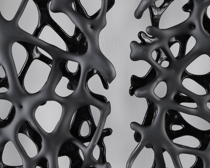 Tracy Nicholls glass wall sculpture Riven — a one-off artwork of two black glass panels forming an orb when placed side by side. The intricate webbed structure undulates with organic movement, featuring a satin-smooth exterior contrasting with a glossy black inner surface that glimmers through the open lace-like forms.