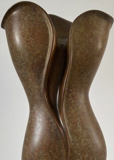 Tall, elegant bronze sculpture with flowing, petal-like curves and a rich earthy brown patina, its organic form rising gracefully from a polished black stone plinth.