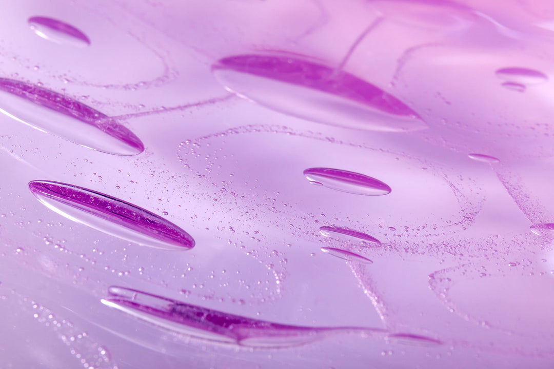Delicately shaped lilac glass vessel with an organic rim and embossed bubble-like texture, set against a white background with soft reflection.