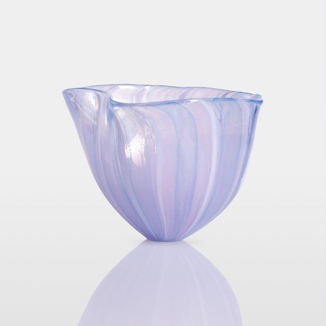 Abstract glass sculpture composed of layered, translucent panels in vivid hues—featuring crisp primary red, vibrant blue, and bright yellow alongside subtle accents of green and purple—set on a sleek black base that accentuates the interplay of light and shadow.
