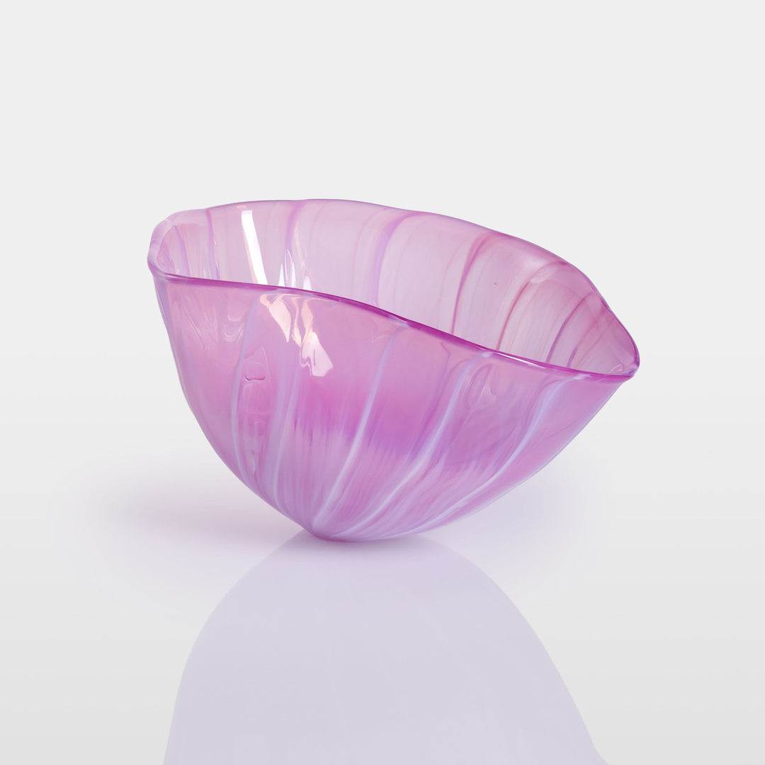 Delicately sculpted blown glass bowl in soft lilac and pink tones, with fluid contours and a translucent finish, displayed against a clean white background.
