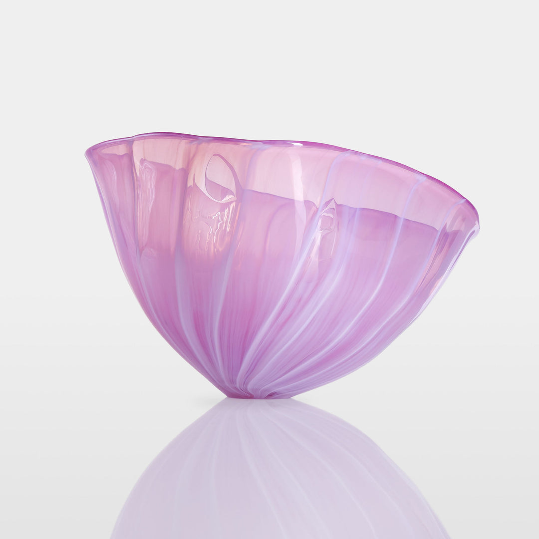Delicately sculpted blown glass bowl in soft lilac and pink tones, with fluid contours and a translucent finish, displayed against a clean white background.