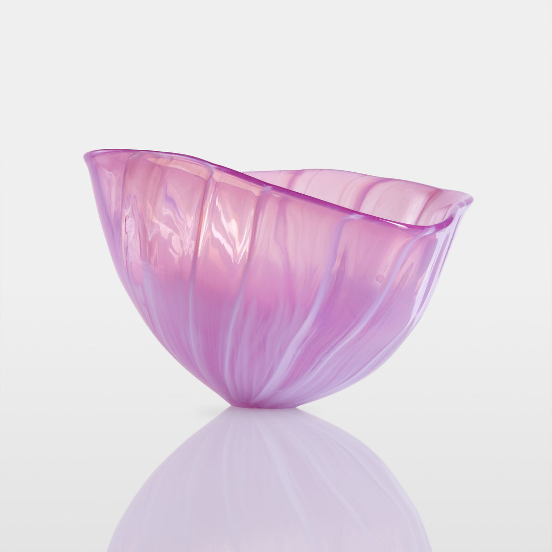 Delicately sculpted blown glass bowl in soft lilac and pink tones, with fluid contours and a translucent finish, displayed against a clean white background.