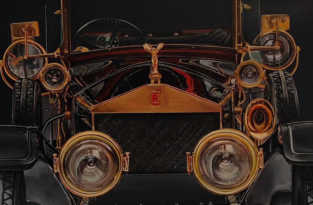 Hyperrealistic painting of a vintage Rolls-Royce viewed head-on, bathed in dramatic golden highlights against a deep black background. The iconic Spirit of Ecstasy hood ornament crowns the polished brass grille, flanked by ornate circular headlights and intricate mechanical details. The symmetrical, imposing composition transforms the car into a symbol of luxury, heritage, and cultural grandeur.