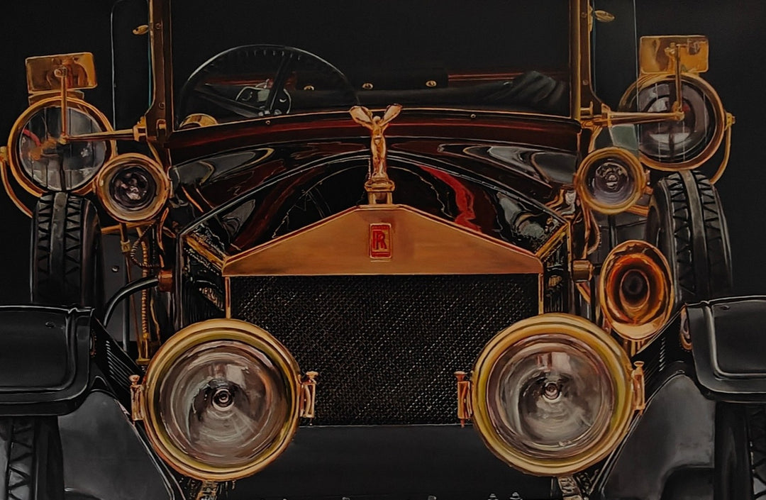 Hyperrealistic painting of a vintage Rolls-Royce viewed head-on, bathed in dramatic golden highlights against a deep black background. The iconic Spirit of Ecstasy hood ornament crowns the polished brass grille, flanked by ornate circular headlights and intricate mechanical details. The symmetrical, imposing composition transforms the car into a symbol of luxury, heritage, and cultural grandeur.