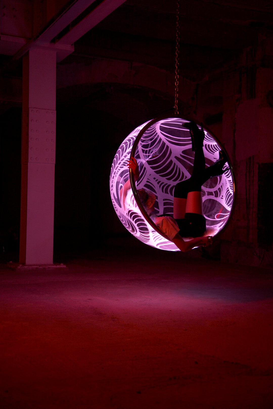 Ben Rousseau, Illuminated Bubble Chair – a limited-edition hanging sphere with engraved acrylic, vibrant pink-purple LED glow, and Mongolian sheepskin cushion featuring INSA’s signature pattern. A cocoon-like statement chair blending art, comfort, and sensory light.