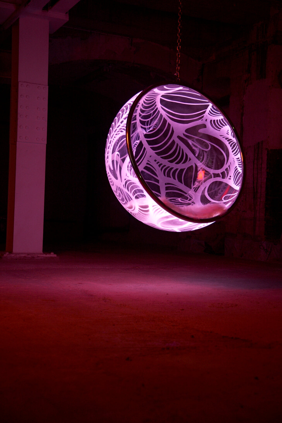 Ben Rousseau, Illuminated Bubble Chair – a limited-edition hanging sphere with engraved acrylic, vibrant pink-purple LED glow, and Mongolian sheepskin cushion featuring INSA’s signature pattern. A cocoon-like statement chair blending art, comfort, and sensory light.