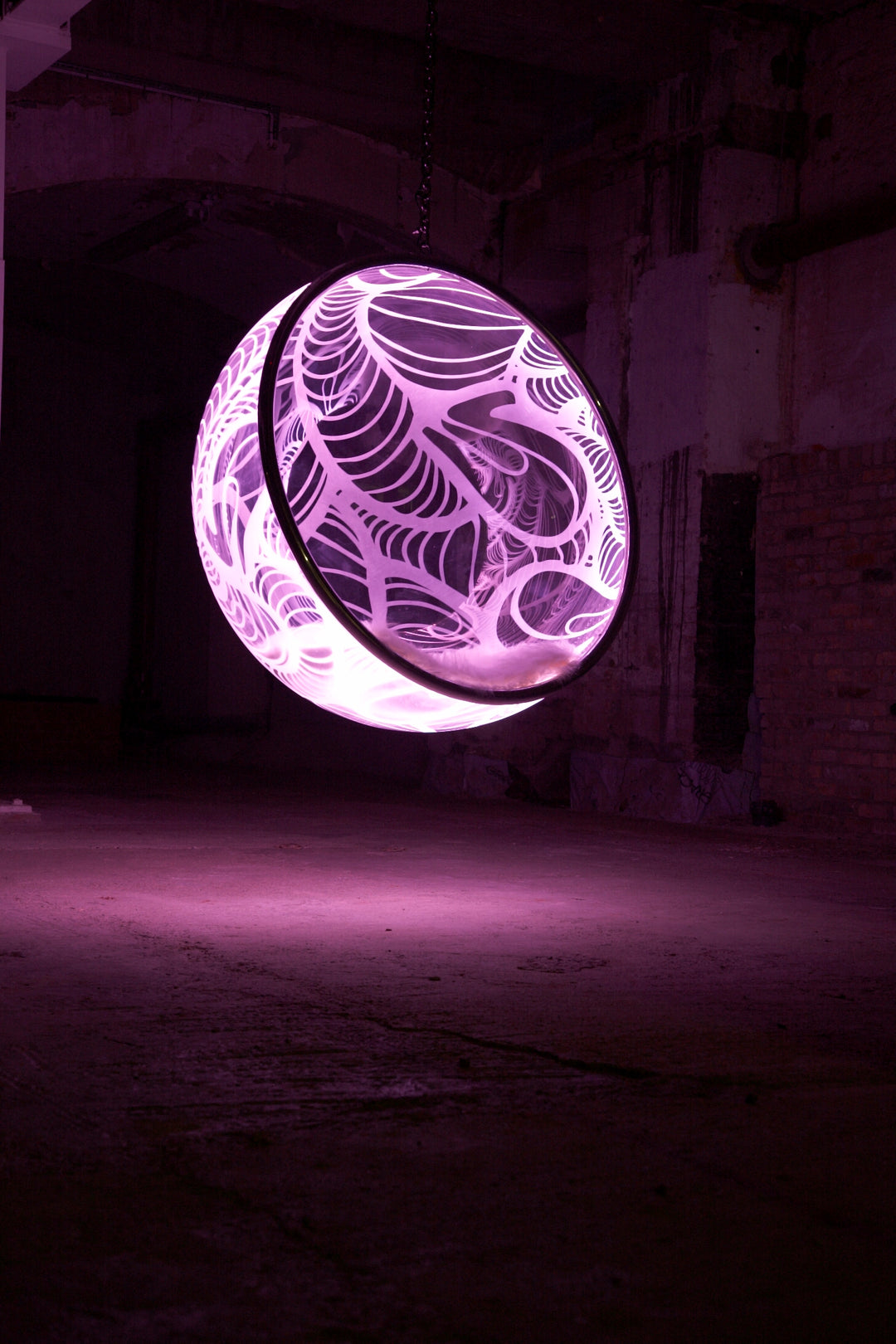 Ben Rousseau, Illuminated Bubble Chair – a limited-edition hanging sphere with engraved acrylic, vibrant pink-purple LED glow, and Mongolian sheepskin cushion featuring INSA’s signature pattern. A cocoon-like statement chair blending art, comfort, and sensory light.