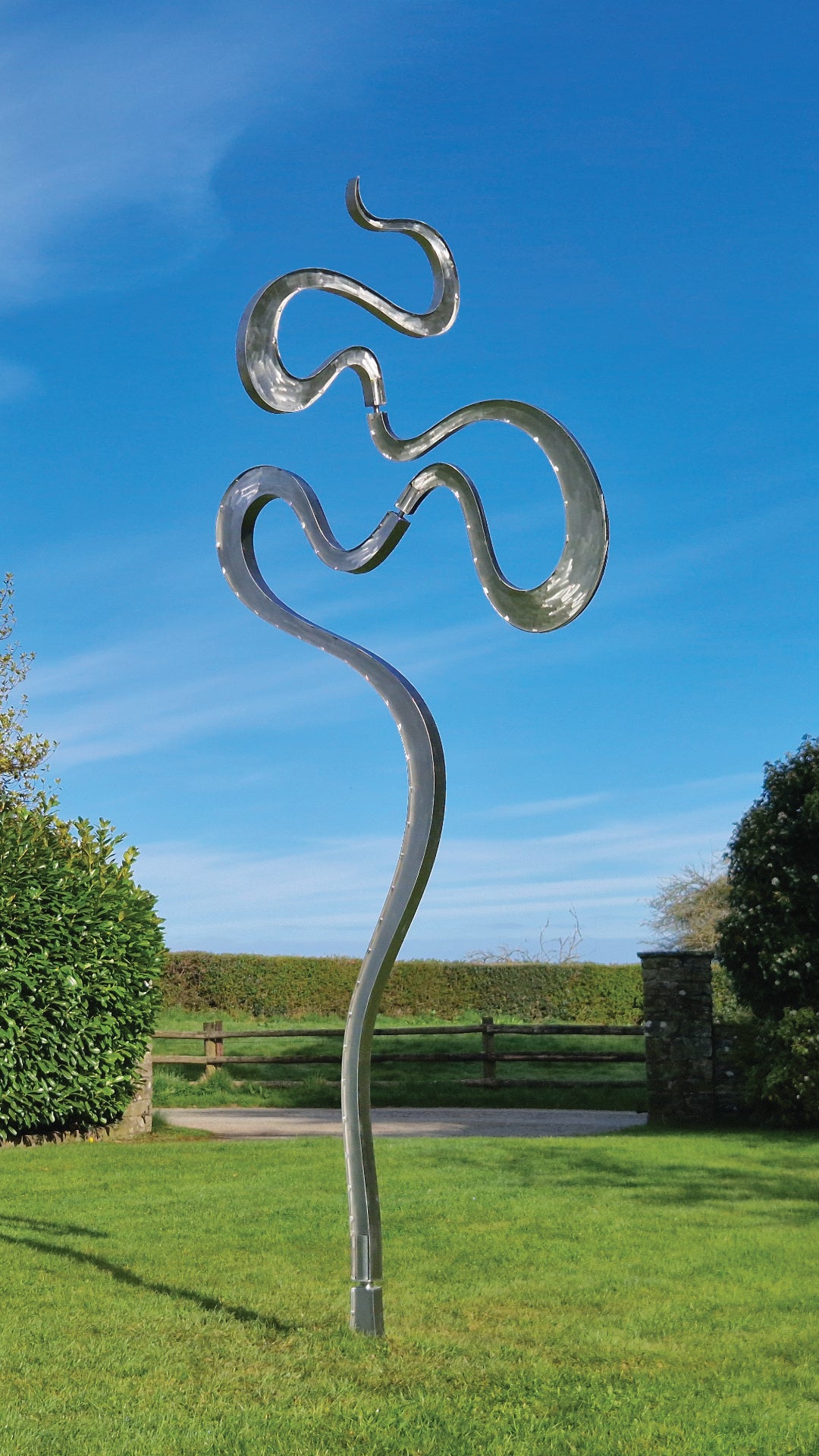Abstract stainless steel kinetic sculpture featuring fluid, serpentine curves that shift gently with the wind