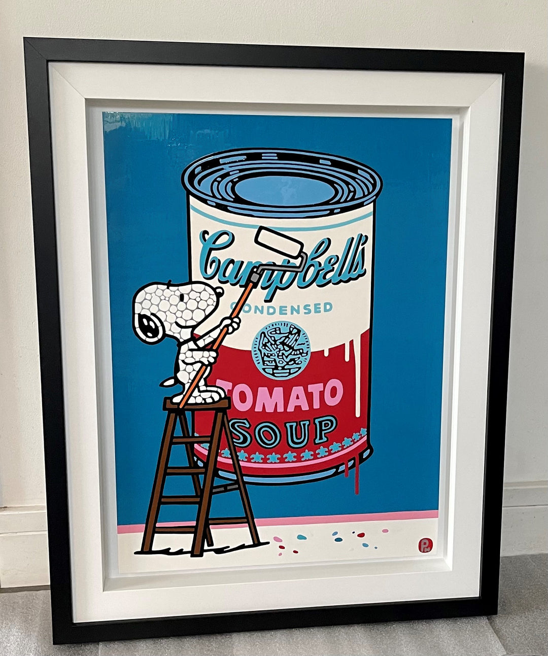 Pop art painting of Snoopy painting a Campbell's soup can on a bright blue background.
