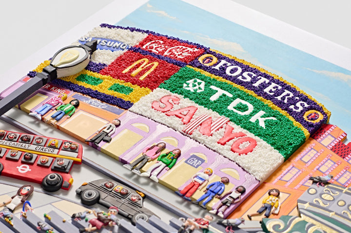 A vibrant, three-dimensional polymer clay artwork of Piccadilly Circus, featuring the iconic curved billboard with brands like Coca-Cola, McDonald’s, and TDK rendered in colourful textured beads. The street scene below includes a classic red double-decker bus marked “38 Piccadilly Circus,” a London black cab, and crowds of joyful figures in bright handmade outfits. Sculpted pigeons dot the grey stone steps beneath the Shaftesbury Memorial Fountain with a golden winged Eros above. 