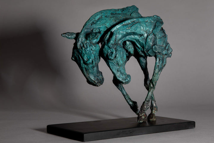 Bronze sculpture of two intertwined horse heads with elongated ears, rendered in a turquoise verdigris finish, symbolising love and hope, mounted on a slate base.