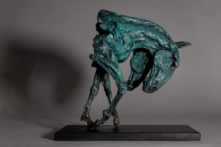 Bronze sculpture of two intertwined horse heads with elongated ears, rendered in a turquoise verdigris finish, symbolising love and hope, mounted on a slate base.