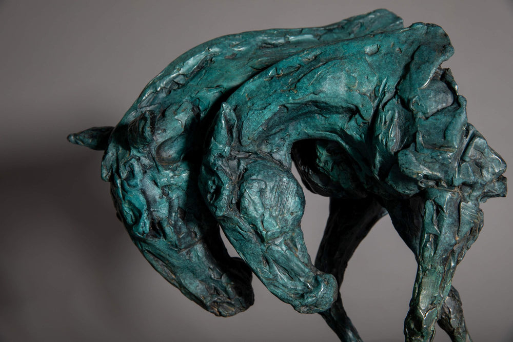Bronze sculpture of two intertwined horse heads with elongated ears, rendered in a turquoise verdigris finish, symbolising love and hope, mounted on a slate base.
