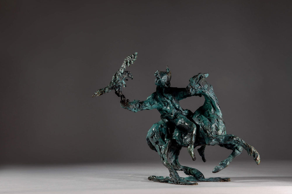 Bronze sculpture of a Mongolian hunter on horseback, shown mid-motion with an eagle perched on the rider’s outstretched arm. The piece features dynamic movement and expressive texture, finished in a rich turquoise verdigris patina.