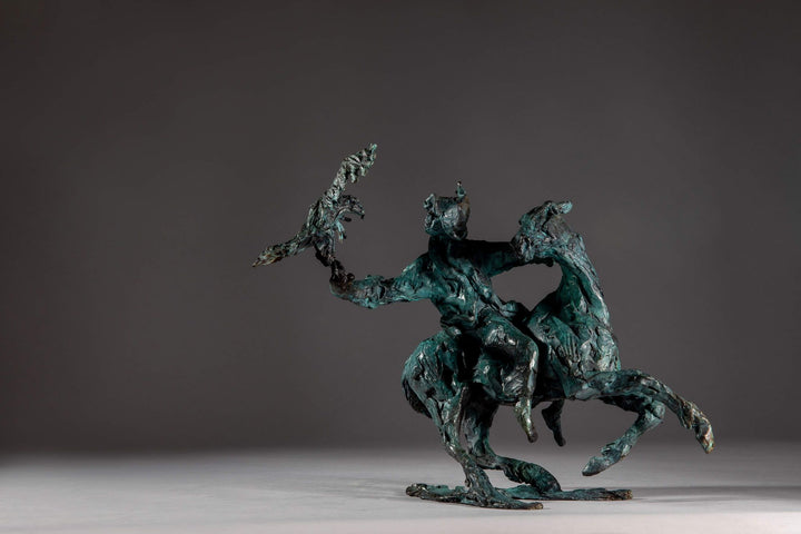Bronze sculpture of a Mongolian hunter on horseback, shown mid-motion with an eagle perched on the rider’s outstretched arm. The piece features dynamic movement and expressive texture, finished in a rich turquoise verdigris patina.