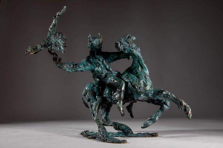 Bronze sculpture of a Mongolian hunter on horseback, shown mid-motion with an eagle perched on the rider’s outstretched arm. The piece features dynamic movement and expressive texture, finished in a rich turquoise verdigris patina.