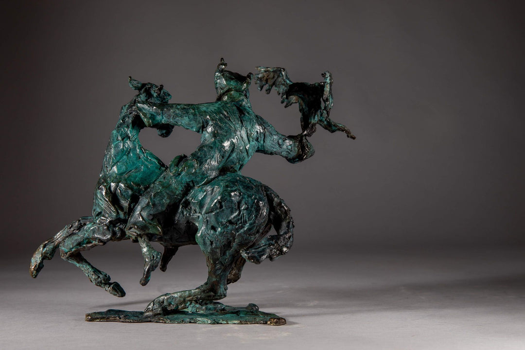 Bronze sculpture of a Mongolian hunter on horseback, shown mid-motion with an eagle perched on the rider’s outstretched arm. The piece features dynamic movement and expressive texture, finished in a rich turquoise verdigris patina.