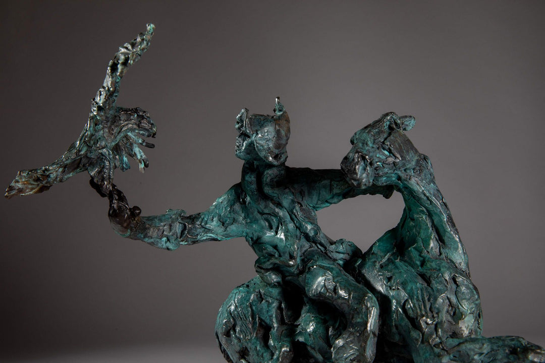 Bronze sculpture of a Mongolian hunter on horseback, shown mid-motion with an eagle perched on the rider’s outstretched arm. The piece features dynamic movement and expressive texture, finished in a rich turquoise verdigris patina.