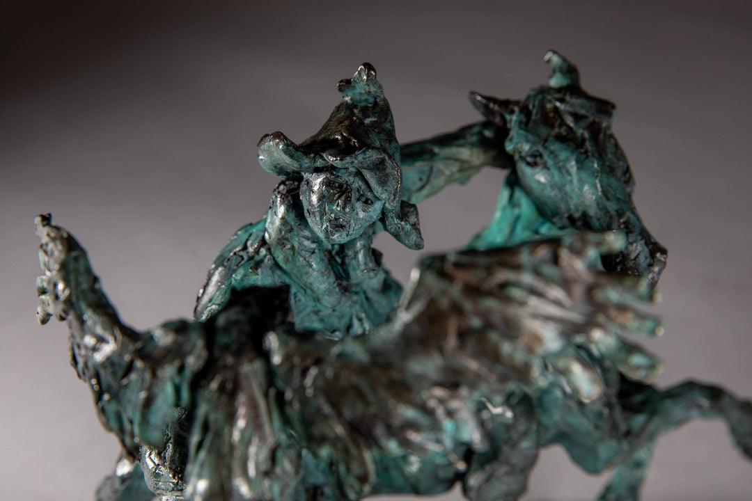 Bronze sculpture of a Mongolian hunter on horseback, shown mid-motion with an eagle perched on the rider’s outstretched arm. The piece features dynamic movement and expressive texture, finished in a rich turquoise verdigris patina.