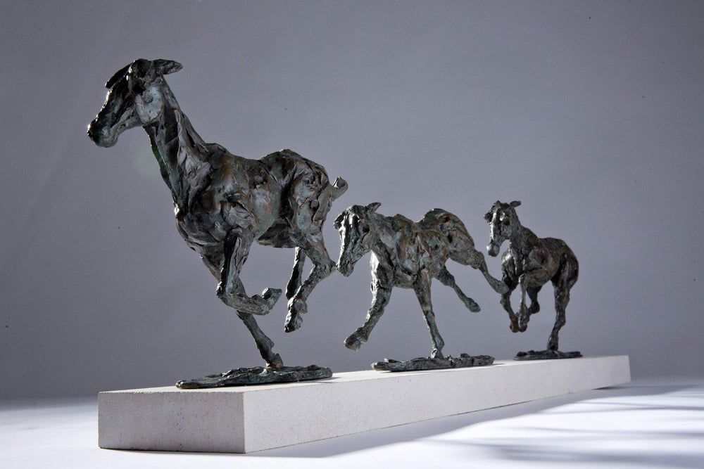 Bronze sculpture of three galloping horses mounted on a Portland stone base, capturing the fluid motion and changing form of equine movement in a verdigris finish.