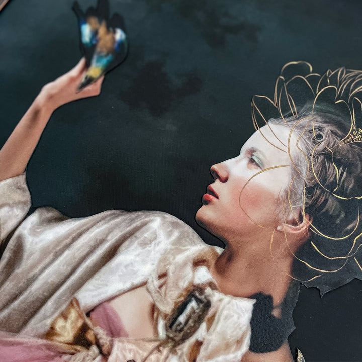 Catarina Diaz’s Set You Free, analogue collage on Somerset Enhanced Velvet with oil on canvas. Rococo-inspired woman in pink gown and ivory robe holds leopard, raises hand to blue-and-gold bird, framed by butterflies and flowers against deep dark backdrop.