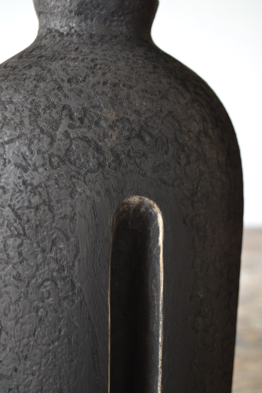 Solitude by Nicola Beattie – tall hand-carved sculpture in charred sycamore and bog oak, with elongated vertical form, deep central recess, and textured blackened surface on rugged base, evoking ancient standing stones and quiet resilience.