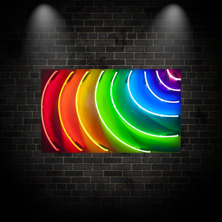 Curved neon light installation by Matthew Bracey forming a radiant spectrum across a wall, with glowing arcs in red, orange, yellow, green, blue, and violet. The light creates a dynamic rainbow effect that spills onto the surrounding surface, showcasing a bold and immersive colour experience.
