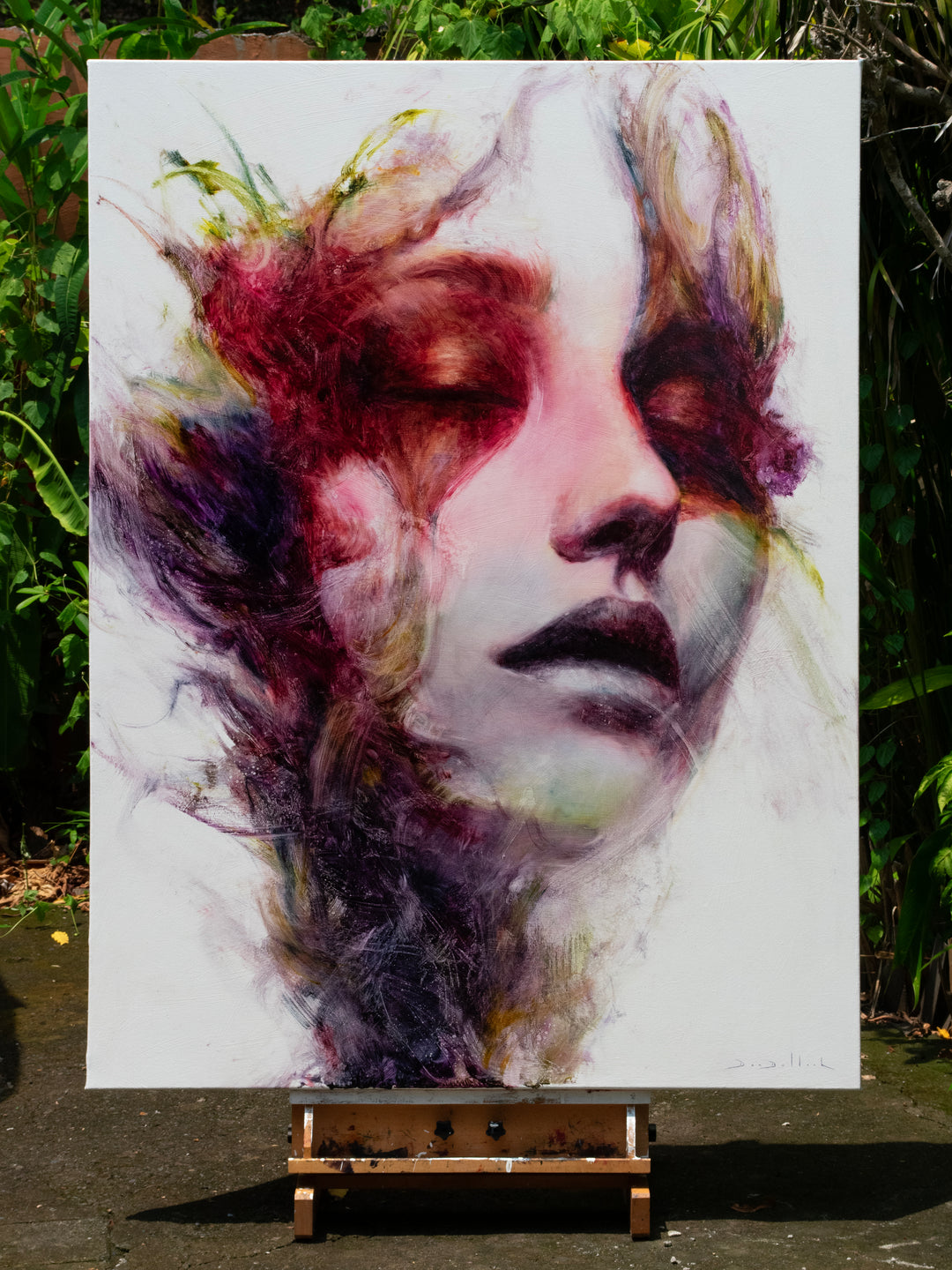 Large oil on canvas portrait by Dan Bullock, titled Spectrum. A dreamlike female face with eyes closed, surrounded by expressive swirls of crimson, violet, emerald, gold, and deep shadow tones, blending realism with abstraction.